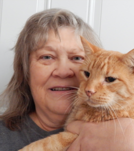 woman holding orange tabby cat