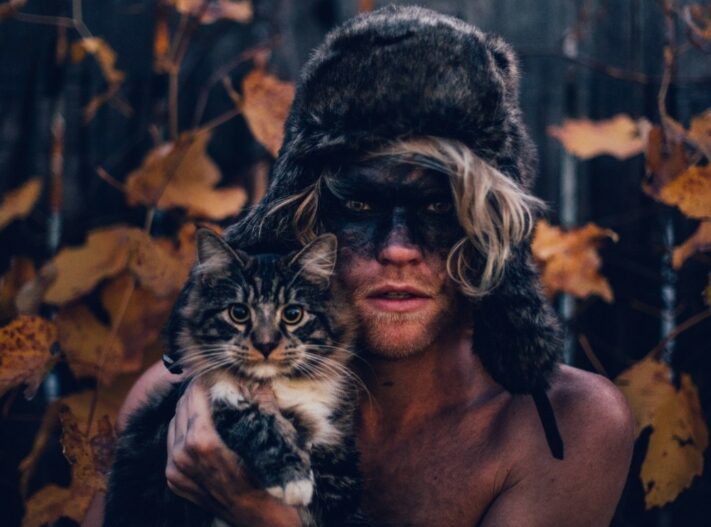 Human in fur hat holding cat