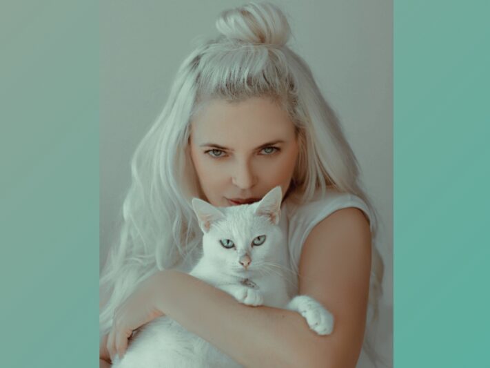 Platinum-haired young woman with white cat