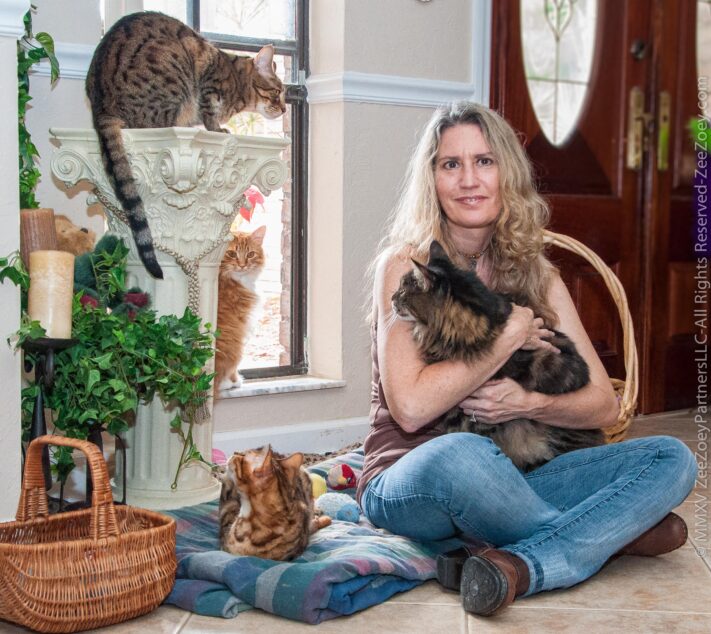 The author, a woman with several cats.