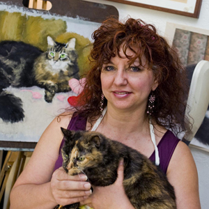 woman holding cat, smiling at camera