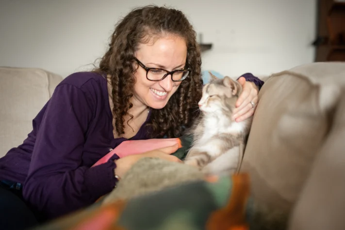 woman sitting on couch with CH cat