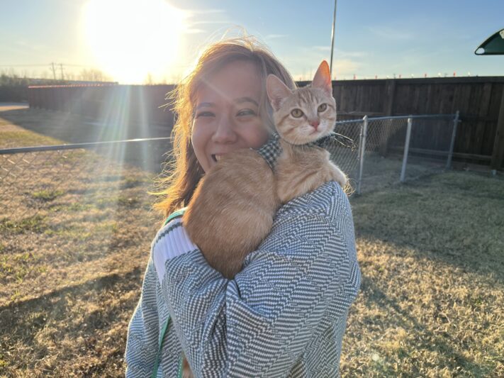 woman with orange cat on her shoulder